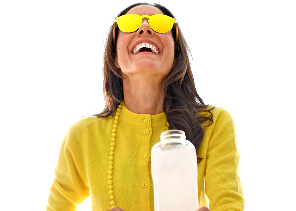 women with yellow sunglasses holding a bottle of water