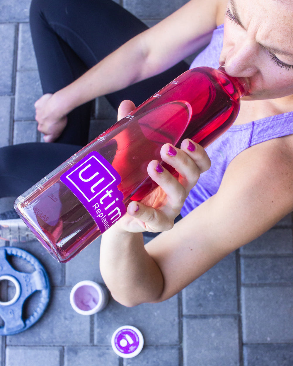 Woman rehydrating after a workout with Ultima Replenisher Electrolyte Hydration Mix