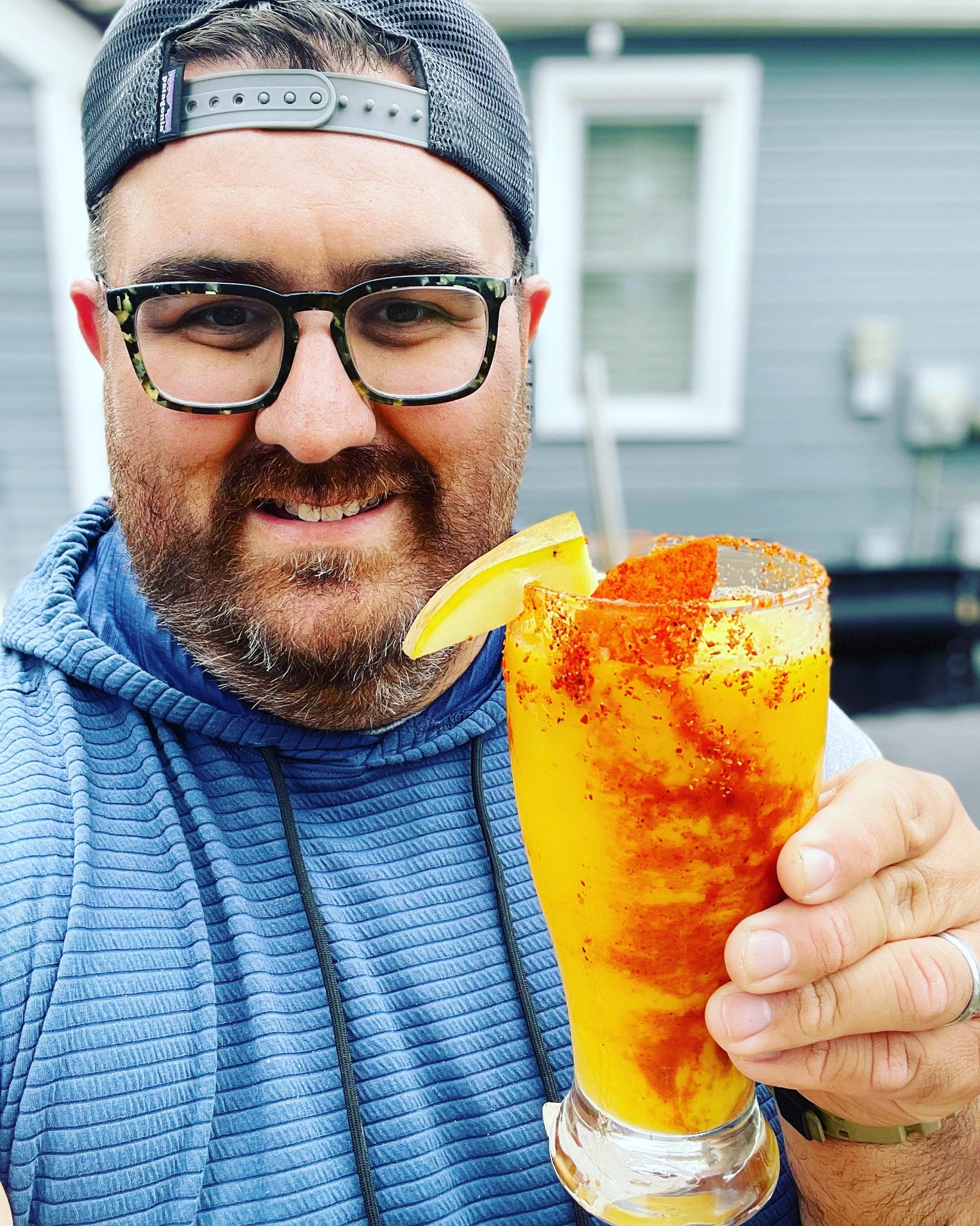 man holding glass with sugar free ultima mangonada cocktail