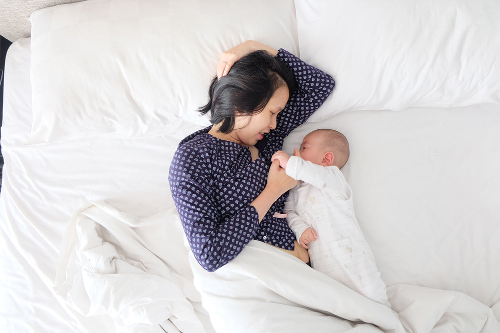 Woman lying in bed with her baby