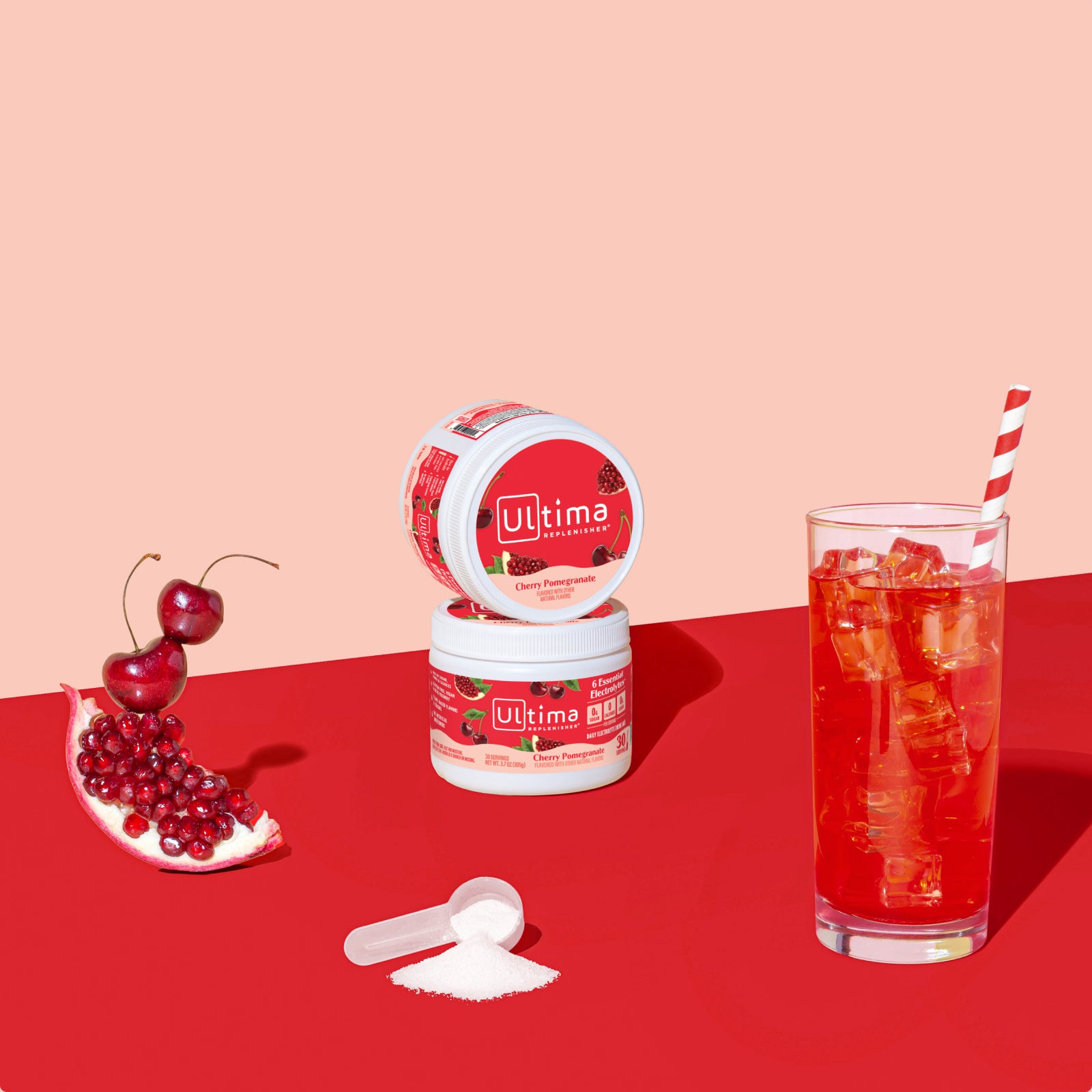 Ultima Replenisher Cherry Pomegranate electrolyte hydration powder 30 serving canister lifestyle with glass and fruit