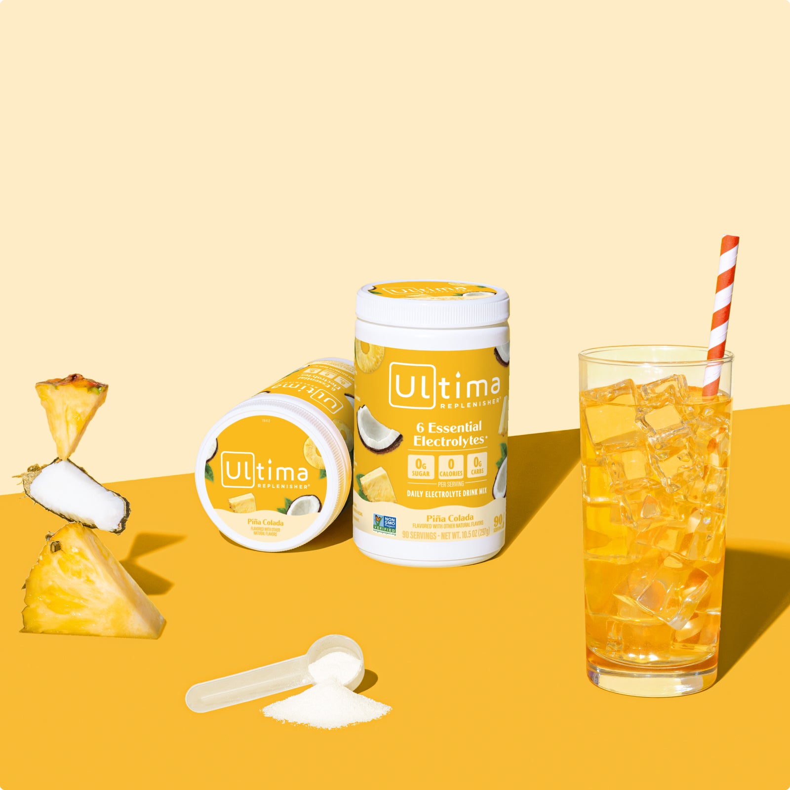 Ultima Replenisher Pina Colada electrolyte hydration powder 90 serving canister lifestyle with glass and fruit