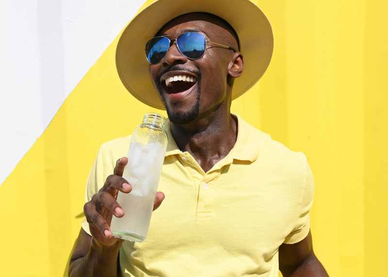 Man in yellow holding Ultima Lemonade Electrolyte Drink