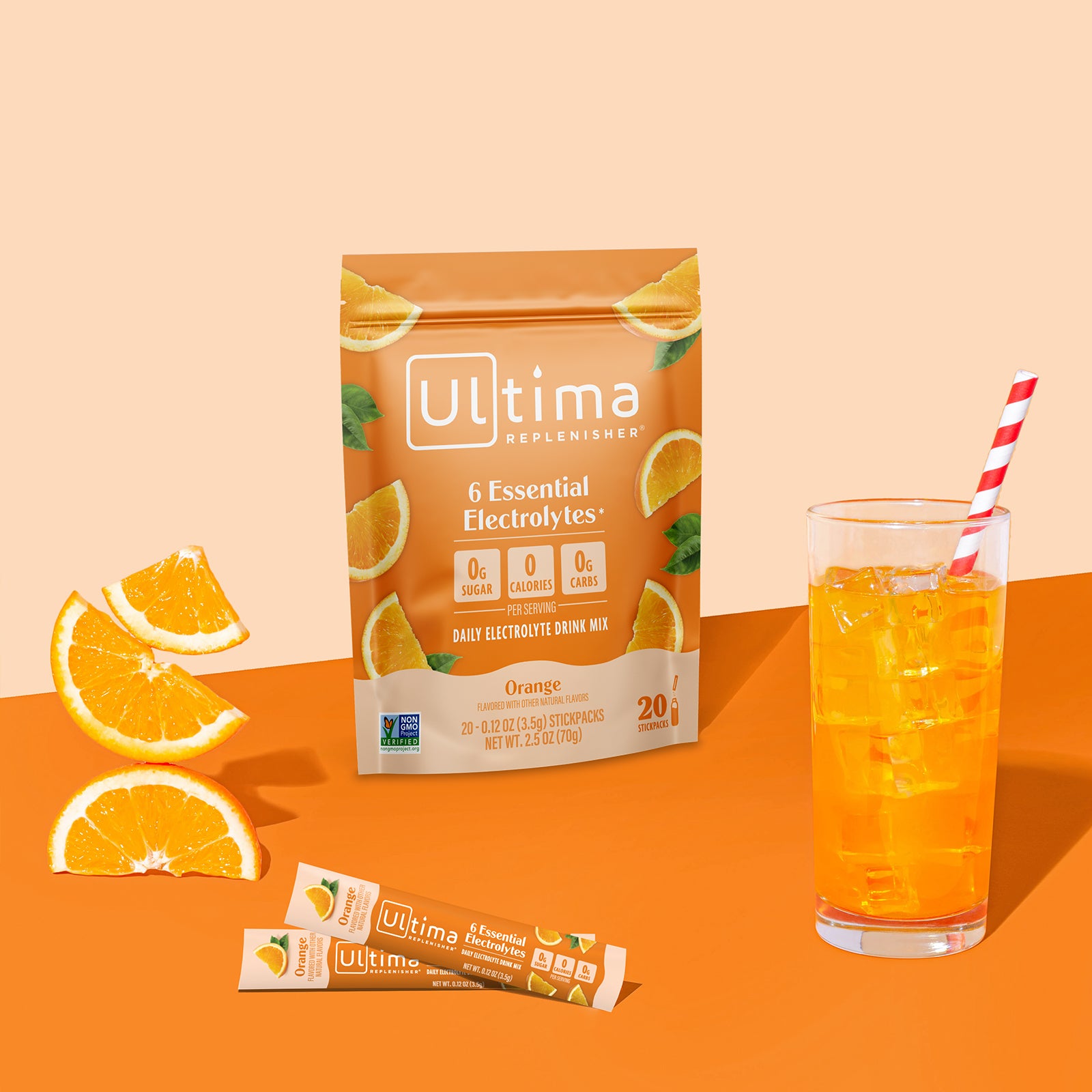 Ultima Replenisher Orange electrolyte hydration powder pouch lifestyle with glass and fruit
