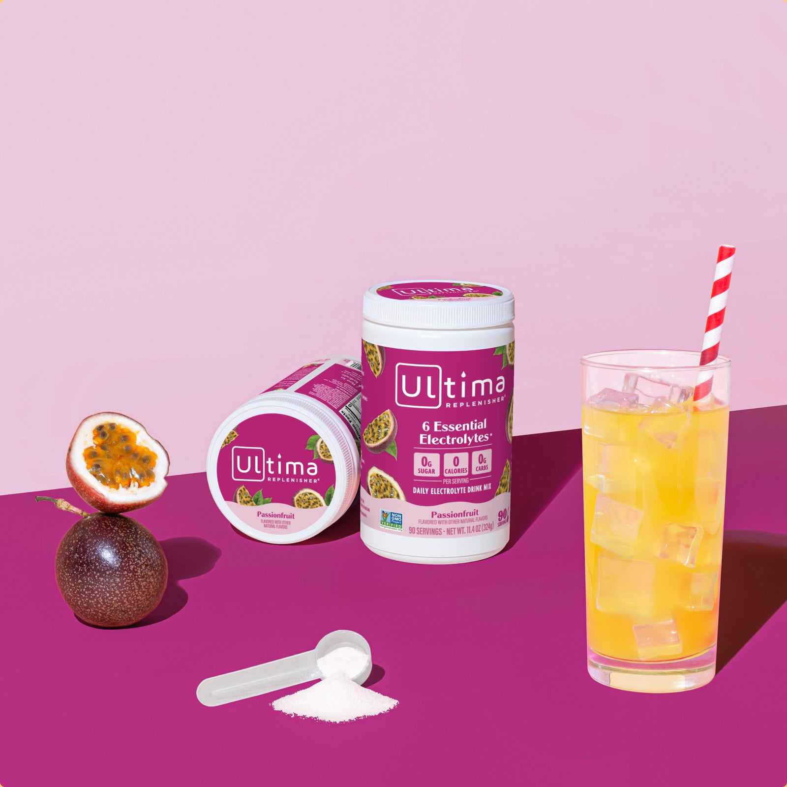 Ultima Replenisher Passionfruit electrolyte hydration powder 90 serving canister lifestyle with glass and fruit