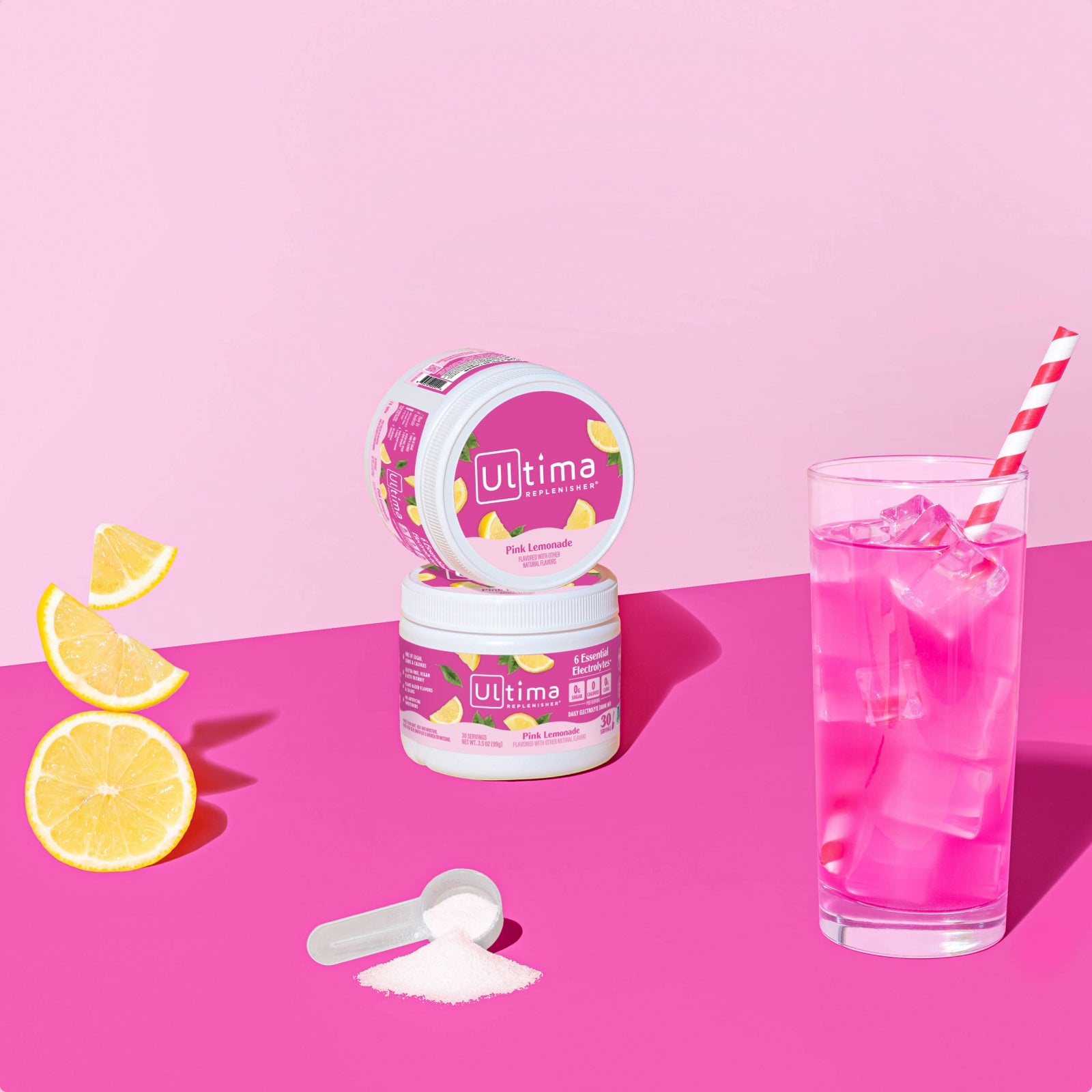 Ultima Replenisher Pink Lemonade electrolyte hydration powder 30 serving canister lifestyle with glass and fruit