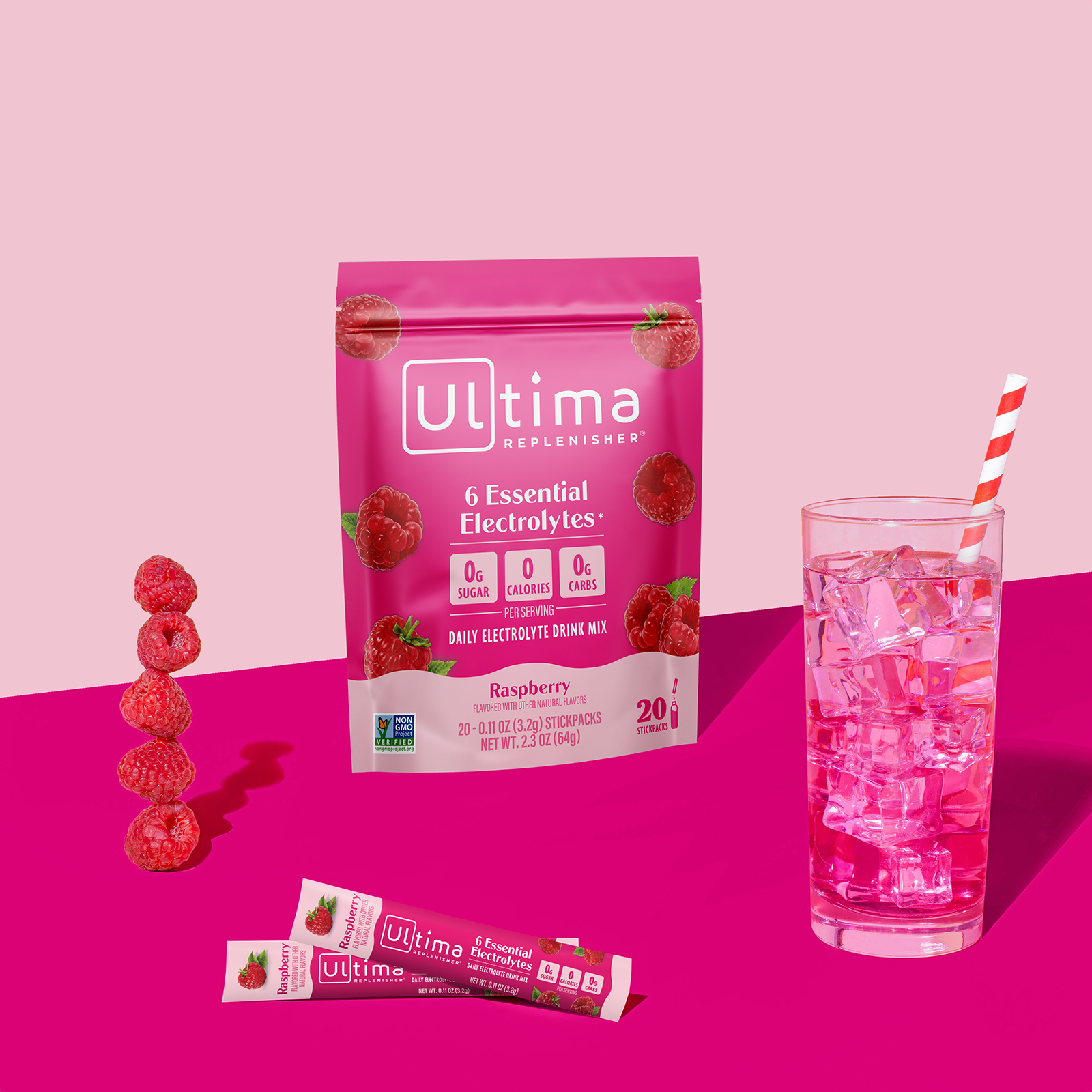 Ultima Replenisher Raspberry electrolyte hydration powder pouch lifestyle with glass and fruit