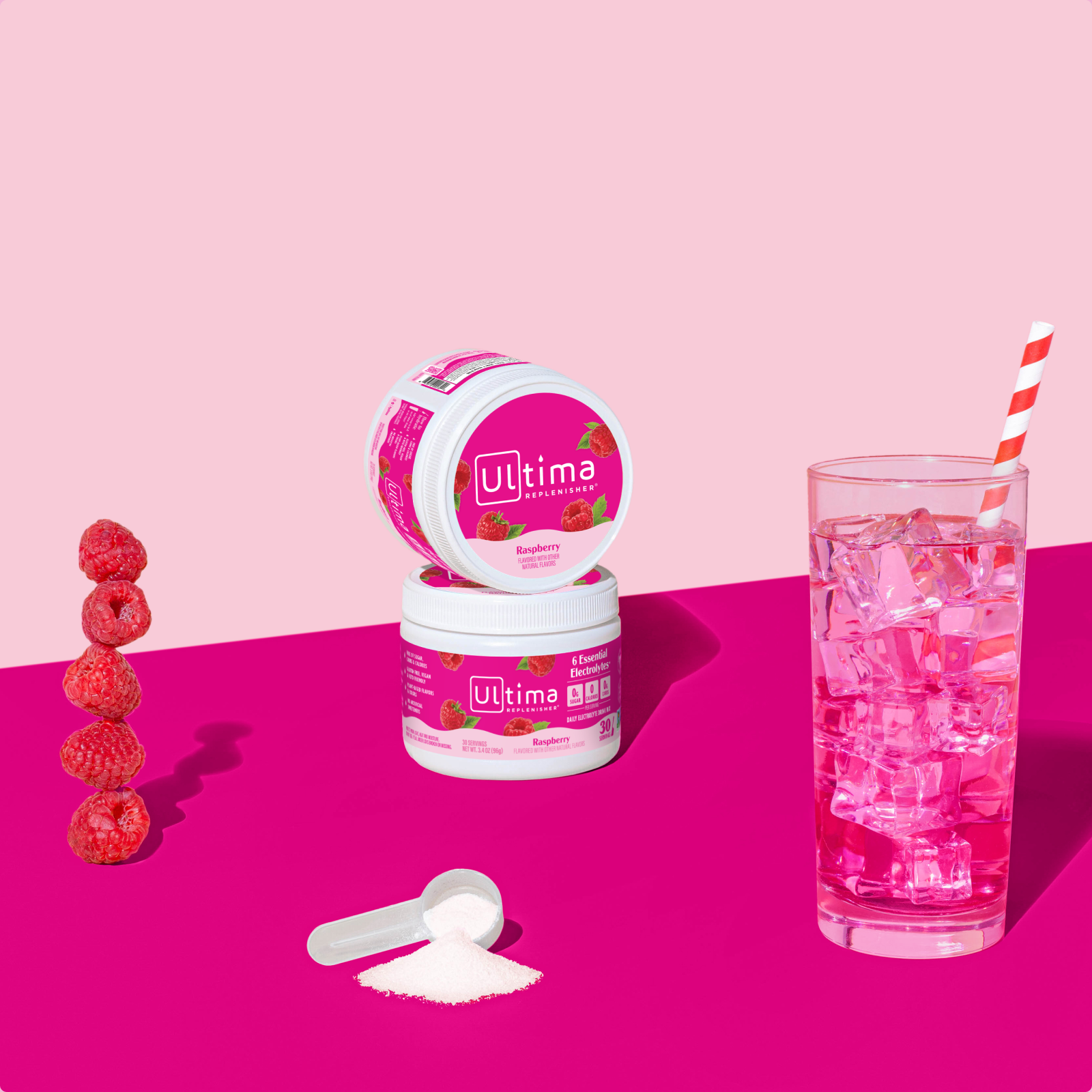Ultima Replenisher Raspberry electrolyte hydration powder 30 serving canister lifestyle with glass and fruit