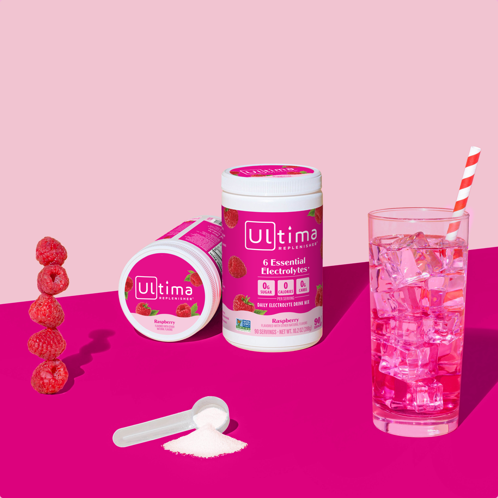 Ultima Replenisher Raspberry electrolyte hydration powder 90 serving canister lifestyle with glass and fruit