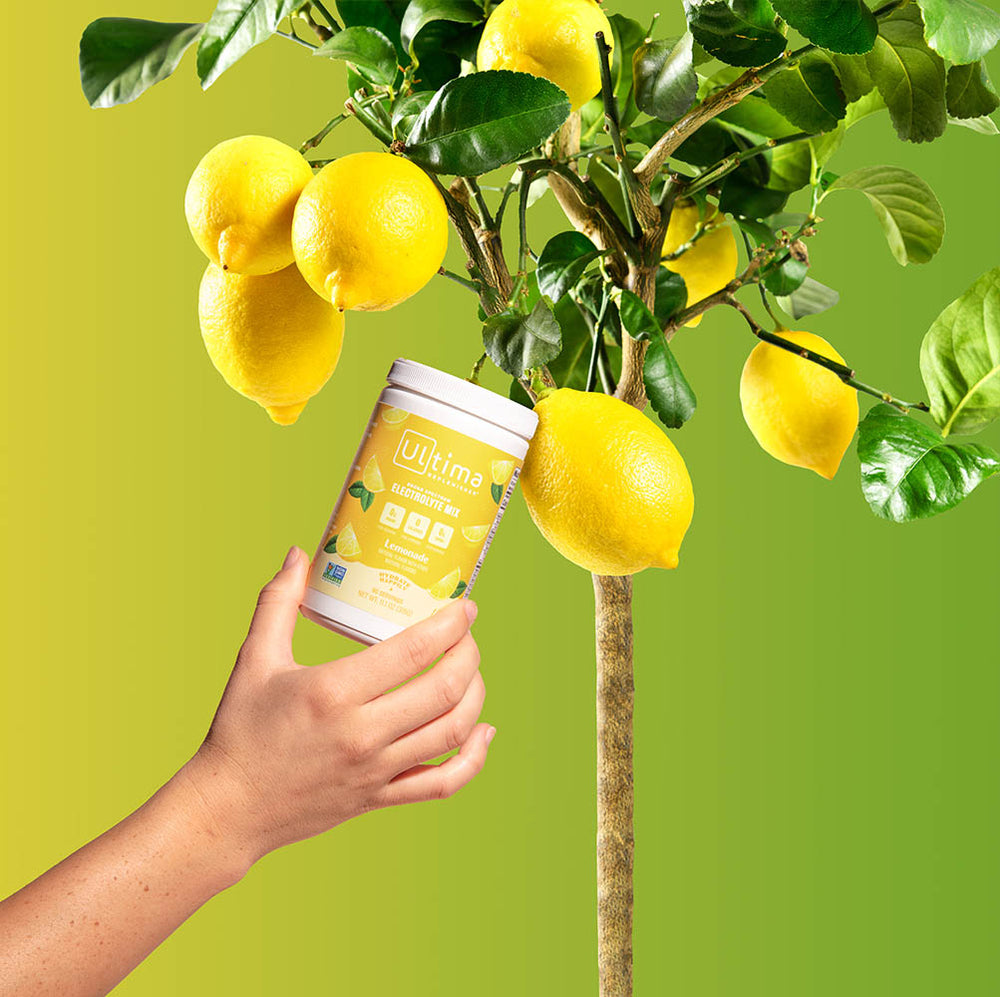 Lemon tree growing lemons and a container of Lemonade Ultima Replenisher