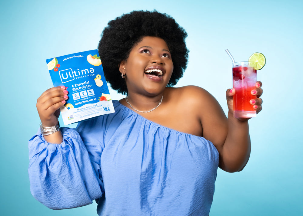 Woman holding Ultima Replenisher Electrolyte Powder Mocktini Stickpacks
